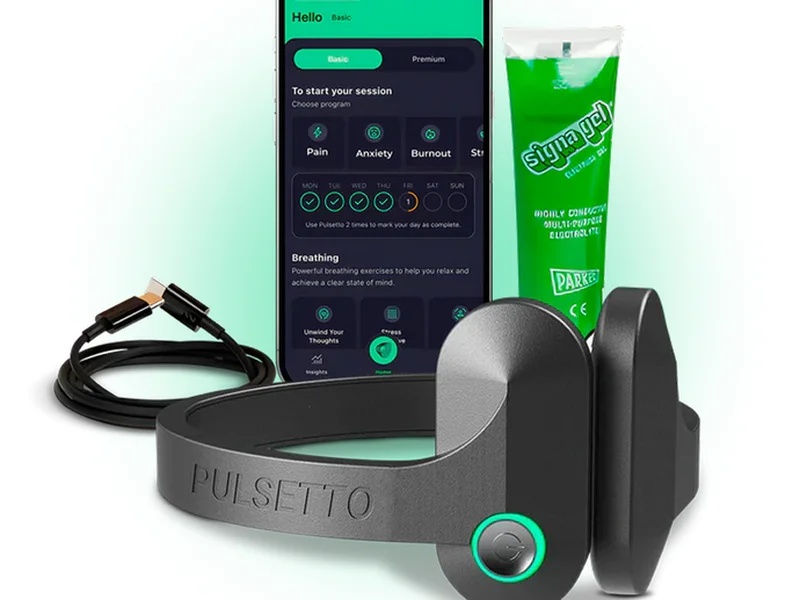 Vagus nerve stimulation device resting on a table beside a phone app